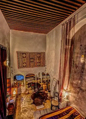 a room with a bed and a table and chairs at Riad Almaz in Fès