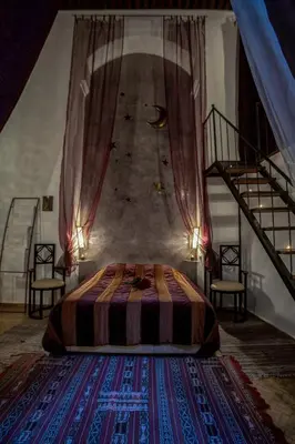 a bedroom with a bed in a room with stairs at Riad Almaz in Fès