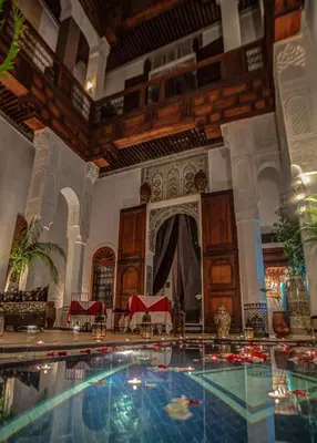 a swimming pool in a large room with a building at Riad Almaz in Fès