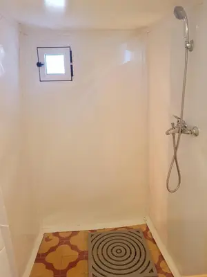 a small bathroom with a shower and a rug at Dune Merzouga Camp in Merzouga