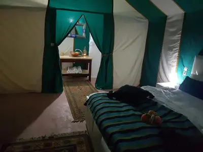 a bedroom with a bed in a tent at Dune Merzouga Camp in Merzouga