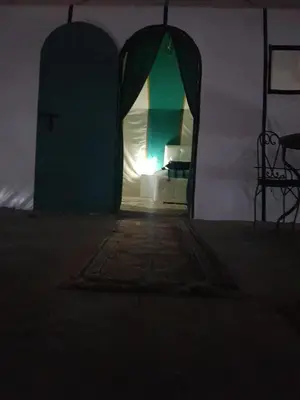 a dark room with a room with a door and a table at Dune Merzouga Camp in Merzouga