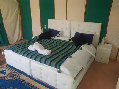 a bedroom with a large bed with towels on it at Dune Merzouga Camp in Merzouga