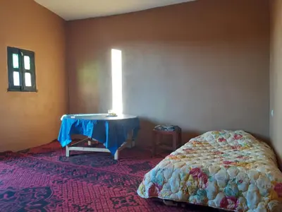 a bedroom with a table and a bed in a room at Sahara Peace in Mhamid