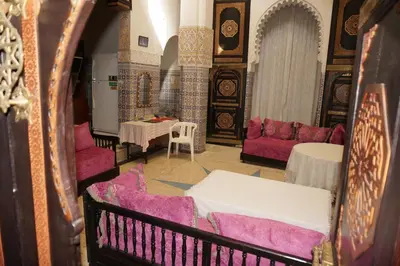 a living room with purple and white furniture and tables at Dar Hlimi in Fès