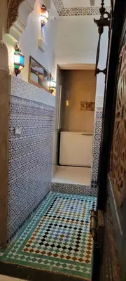 an empty room with blue and white tiles on the wall at Dar Hlimi in Fès