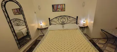 a bedroom with a large bed with a mirror at Dar Hlimi in Fès