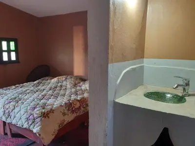 a bathroom with a sink and a bed at Sahara Peace camp in Zagora