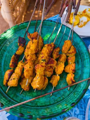 a plate of food on a table with sticks at Sahara Peace camp in Zagora