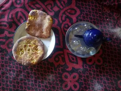 a plate of food with a muffin and a cup at Sahara Peace camp in Zagora