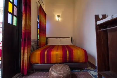 a bedroom with a bed with a colorful blanket at Riad Taha in Fès