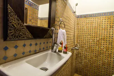 a bathroom sink with a statue of a girl on it at Riad Taha in Fès