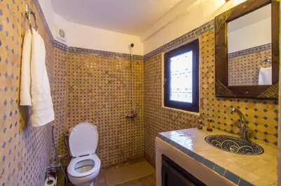 a bathroom with a toilet and a sink and a mirror at Riad Taha in Fès