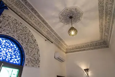 a room with a ceiling with a chandelier and a window at Riad Taha in Fès