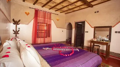 a bedroom with a bed with a necklace on it at Ecolodge l'île de Ouarzazate in Ouarzazate