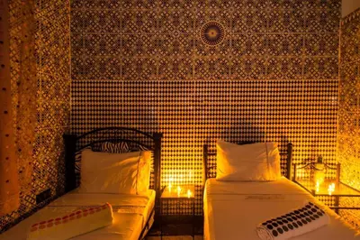 two beds in a room with candles and lights at Dar Berrada-Ziat in Fès