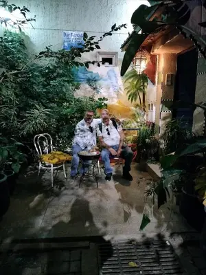 two older men sitting on a bench in a garden at Dar Berrada-Ziat in Fès