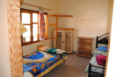 a bedroom with a bunk bed and a window at Auberge Restaurant Rooftop Tamazirt in Boumalne