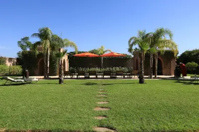 a path in the grass in a park with palm trees at Villa Jannah in Marrakech