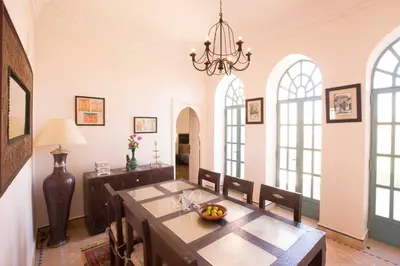 a dining room with a table and chairs and a chandelier at Villa Jannah in Marrakech
