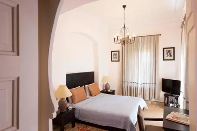 a bedroom with a white bed and a chandelier at Villa Jannah in Marrakech
