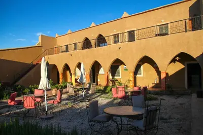 a group of tables and chairs in front of a building at Skoura Lodge in Skoura
