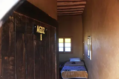 a room with two beds and a door with a sign on it at Skoura Lodge in Skoura