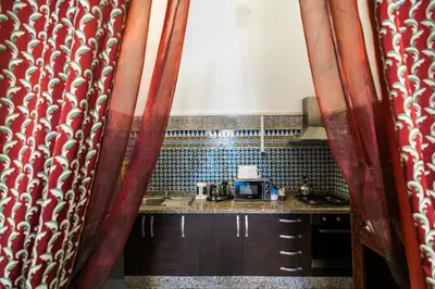 a small kitchen with red curtains and a counter at 2 BR Charming Apartment Fes in Fès