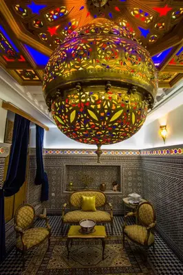 a large chandelier in a room with chairs and a table at Riad Amor - Suite & Spa in Fès
