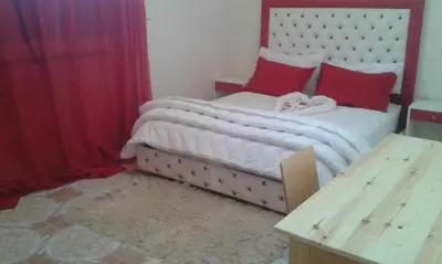 a bedroom with a large bed with red pillows at Hotel School Ersat Azrou in Azrou