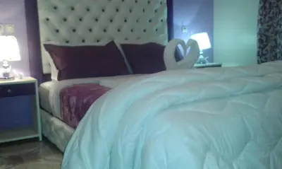 a bedroom with a white bed with a swan on it at Hotel School Ersat Azrou in Azrou