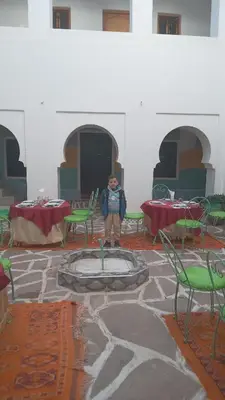 a person standing in a room with chairs and tables at Riad Amodou in Tinerhir