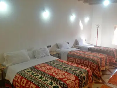 a room with two beds with colorful blankets at Riad Amodou in Tinerhir