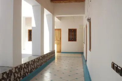 a hallway with white walls and a tiled floor at Riad Amodou in Tinerhir