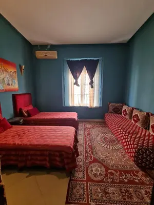a blue room with two beds and a window at youssef in Fès