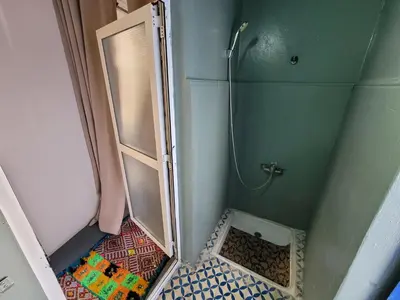 a small bathroom with a shower with a glass door at youssef in Fès