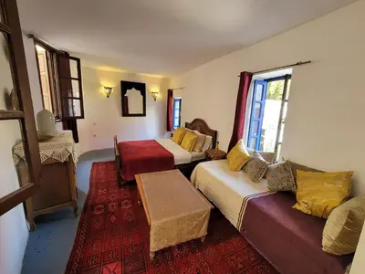 a hotel room with two beds and a couch at youssef in Fès