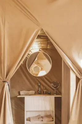 a bathroom with a mirror and a sink in a tent at Caravanserai Luxury Desert Tented Camp in Merzouga