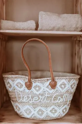 a white bag with a brown handle on a shelf at Caravanserai Luxury Desert Tented Camp in Merzouga