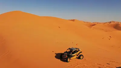 a jeep parked on top of a sand dune at Caravanserai Luxury Desert Tented Camp in Merzouga