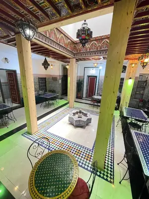 a room with a table and chairs on a floor at La Casa Espanyola in Fès