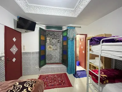 a room with two bunk beds and a tv on the ceiling at La Casa Espanyola in Fès