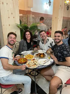 a group of people sitting around a table with food at La Casa Espanyola in Fès