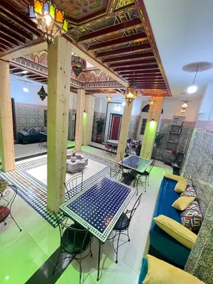 a patio with tables and chairs and a pool at La Casa Espanyola in Fès