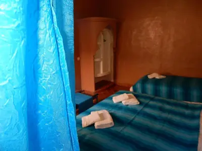 a room with a bed with two towels on it at Riad Tazawa in Ibrahene