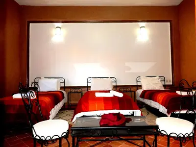 a room with two beds and a large screen at Riad Tazawa in Ibrahene