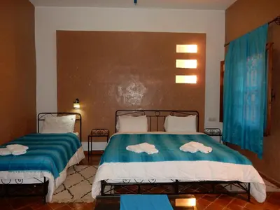 two beds in a room with towels on them at Riad Tazawa in Ibrahene