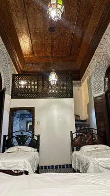 a bedroom with two beds and a wooden ceiling at Dar El Arfaoui in Fès