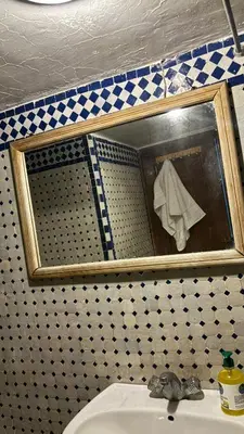 a mirror above a sink in a bathroom at Dar El Arfaoui in Fès