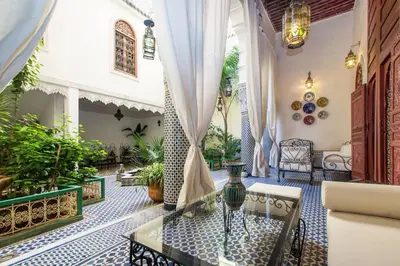 a living room with a glass table in a house at Riad Vega in Fès